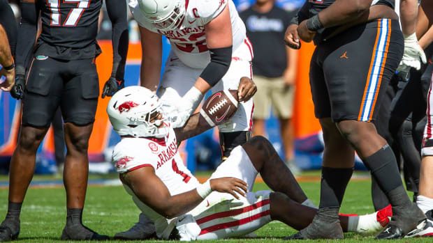Razorbacks quarterback KJ Jefferson gets help from Brady Latham  after run against Florida